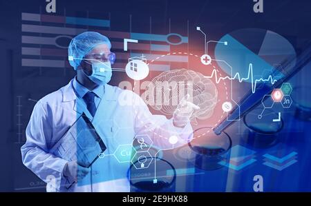 Young doctor using virtual screen on dark background Stock Photo