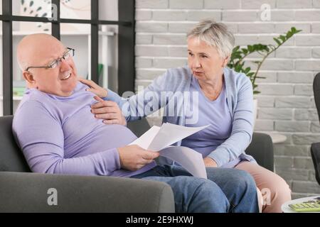 Stressed senior couple in debt at home Stock Photo