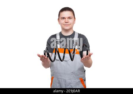 male mechanic in gray uniform holds coil spring in hands car spare part of automobile suspension, shop offer to buy iron product isolated on white bac Stock Photo