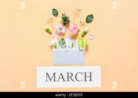 Composition with envelope, beautiful flowers and word MARCH on yellow ...