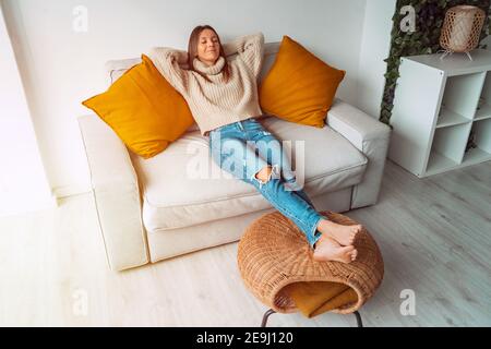 Calm satisfied woman relaxing or sleeping on the sofa in living room Stock Photo