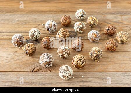 Energy protein balls with healthy ingredients on wooden table. Home made with dates, almond, flax and seeds