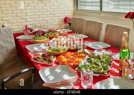 Laid festive table with butterbrods with red and black caviar, salads and hot snacks Stock Photo