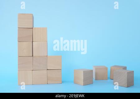 Broken or fallen building blocks in blue background. Economic crisis ...