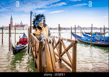 Venice carnival figure in front of the lagoon and the island of San Giorgio Maggiore in Venice, Veneto, Italy Stock Photo