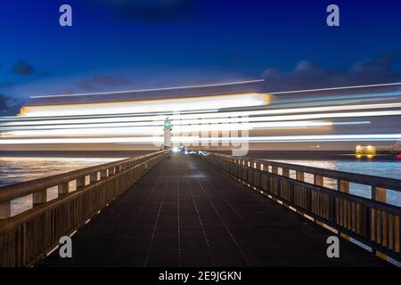 Ferry passant devant la jetée de Calais la nuit, en pose longue, France, Pas de Calais, hiver Stock Photo