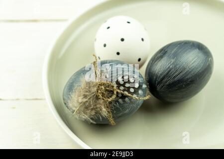 Natural dyed grey Easter eggs in a plate on rustic wooden background. High angle view point Stock Photo