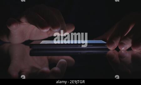 Night Shoot with a Businessman Using Cell Phone Communication. Man Text on a Smartphone. Stock Photo