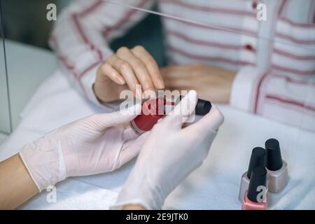 Close up picture of nail artists hands doing nail polishing Stock Photo