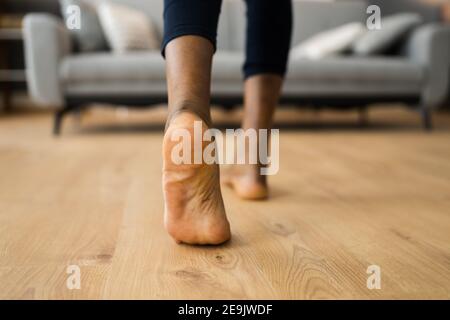 African Barefoot Woman Walking On Heated Floor In Living Room Stock Photo