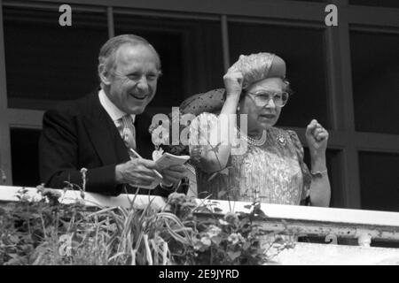 File photo dated 07/06/89 of Queen Elizabeth II cheering on her horse with private secretary Sir William Heseltine from the royal box at Epsom Racecourse. The Queen will have reigned as monarch for 69 years on Saturday. Stock Photo
