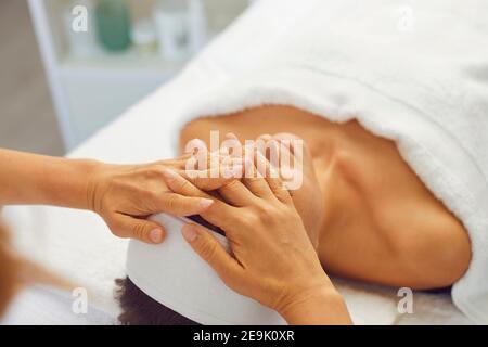 Woman getting professional face lifting massage while relaxing in modern spa salon Stock Photo