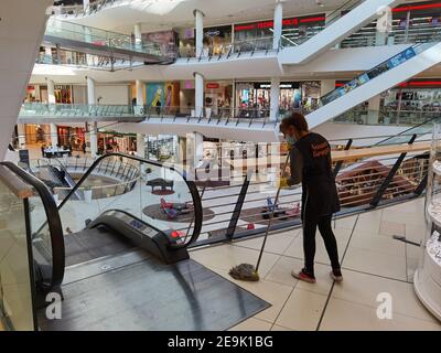 Sofia, Bulgaria - Feb 1 2021: A woman in protective mask is cleaning the floor at Serdika shopping center preparing the center for visitors on the re- Stock Photo