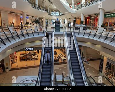 Sofia, Bulgaria - Feb 1 2021: Serdika shopping center re-opening day: visitors using the elevators in protective mask in the almost empty center. Stock Photo