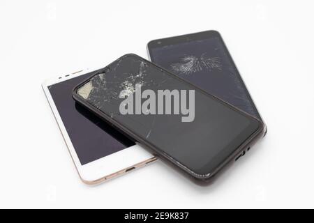 Broken mobile phones with cracked smashed screens, uk Stock Photo