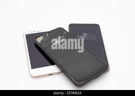 Broken mobile phones with cracked smashed screens, uk Stock Photo