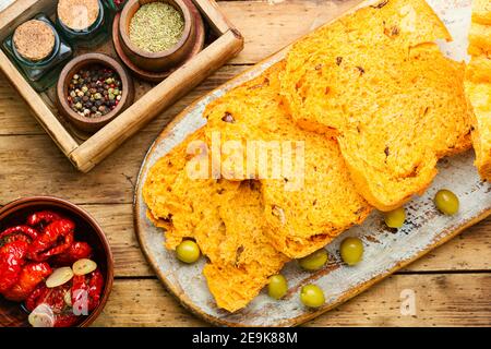 Homemade sliced bread with sun-dried tomatoes on wooden table Stock Photo