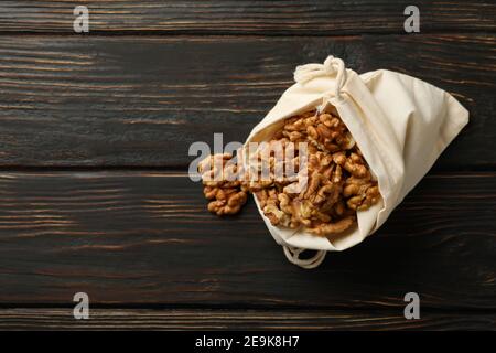 Cotton bag with tasty walnuts on wooden background Stock Photo