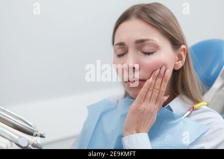 Young woman suffering from toothache waiting for dental treatment at the clinic Stock Photo