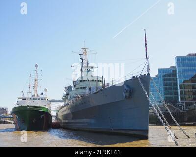 historic ship H.M.S. Belfast on the river Thames in London with the greenpeace ship  Stock Photo