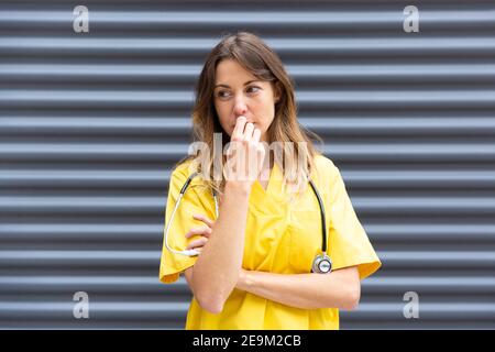 Portrait of young girl doctor pensively and with concerned gesture. Space for text. Stock Photo