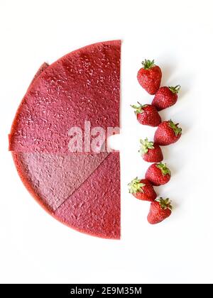 Red strawberry fruit leather slices and berries isolated on white background. Top view, flat lay. Stock Photo