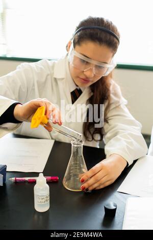 Teenage female student performing a science experiment Stock Photo