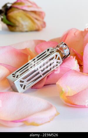 Vintage Silver Perfume Vial on Rose Petals, USA  1940s Stock Photo