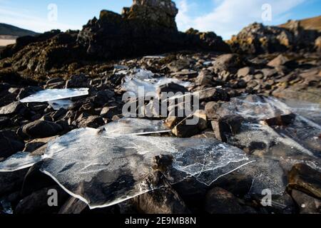Frozen freshwater on the beach/rocks. Sheet ice Stock Photo