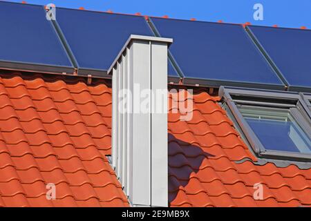 Chimney with stainless steel cladding on a newly covered roof Stock Photo