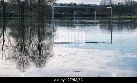 Flooded soccer football field with reflections of the goals in standing water during the flood natural disaster of the Rhine and Main in February 2021 Stock Photo