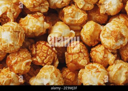 Caramel popcorn close-up as a background, full-screen texture. Admirable praise for watching movies, TV series, cartoons. Close-up, top view Stock Photo