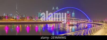 Dubai - The evening skyline with the arched bridge over the new Canal and Downtown. Stock Photo