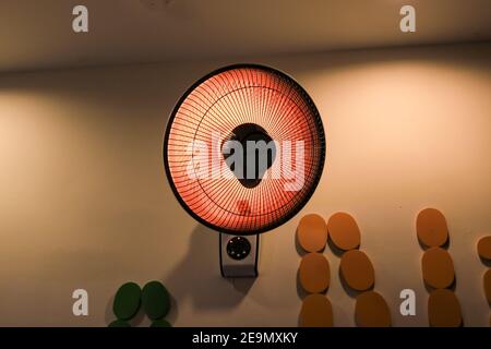 Heating fan with thermal radiation on yellow background Stock Photo