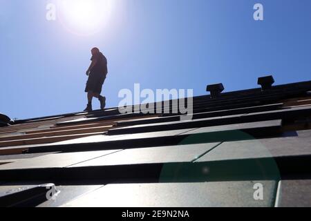 Silhouette of a roofer in the backlight Stock Photo