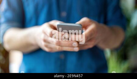 Male hands typing on smartphone Stock Photo