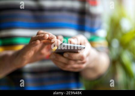 Male hands typing on smartphone Stock Photo