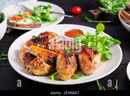 Grilled chicken wings. Baked chicken wings on wooden table. Stock Photo