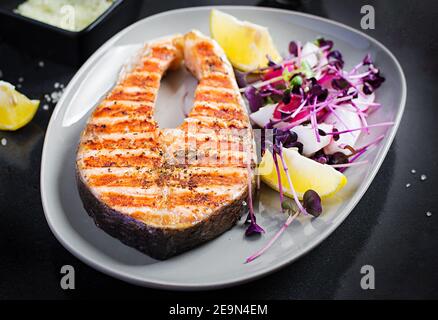 Salmon. Salmon fish steak grilled and radish salad with microgreens. Healthy food. Stock Photo