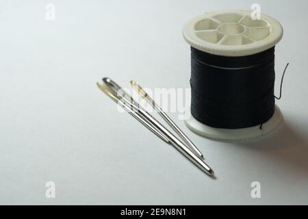 Black Thread With A Needle And A Spool Of Threads On A White Background  Stock Photo, Picture and Royalty Free Image. Image 99466912.