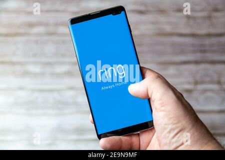 A Mobile phone or cell phone being held showing the Ring doorbell app open on screen Stock Photo