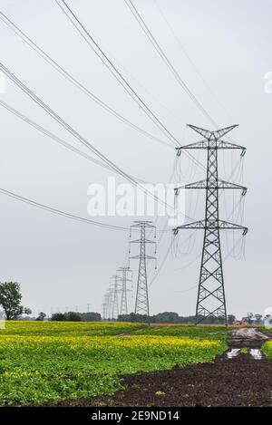 Extra-high voltage 400 kV overhead power line on large pylons, used for long distance, very high power transmission. Cloudy sky and copy space Stock Photo