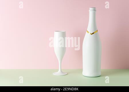White champagne bottle and champagne glass on bright background.. Minimal party concept. Stock Photo