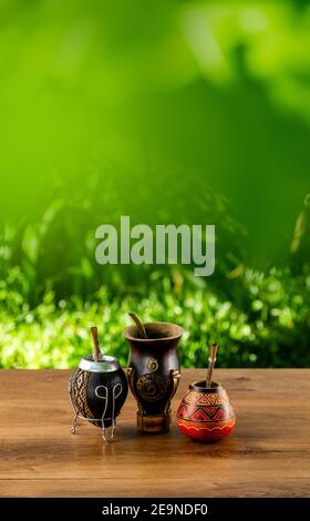 Vertical closeup of a cup of yerba mate infusion with a thermos. Stock  Photo by wirestock