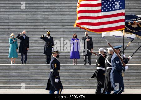 U.S President elect Joe Biden and Vice President elect Kamala Harris review the troops from the capitol steps during the start of the nauguration Day parade January 20, 2021 in Washington, DC. Standing from left to right are: First Lady Dr. Jill Biden, President Joe Biden, Major General Omar J. Jones IV, Vice President Kamala Harris and Second Gentleman Doug Emhoff. Stock Photo