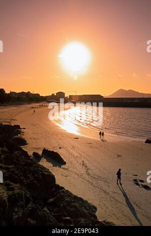 Europe, Spain, Galicia, Porto do Son, Beach Sunset with distant Harbour Wall Stock Photo