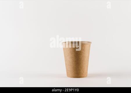 Eco-friendly natural coffee cup with empty space. Disposable ecological utensils on white background. Sustainability of planet. Cardboard glass made o Stock Photo