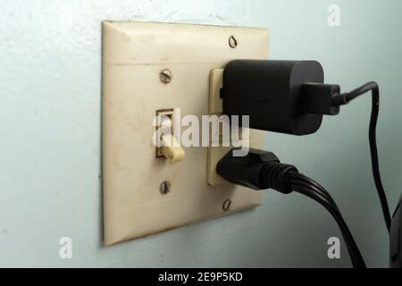 This dirty, grimy, yellowing light switch supports a few appliances via its two GFCI outlets. Stock Photo