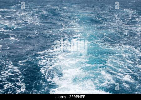 Boat Wave ocean trace on blue sea water wake of cruise liner background. Deep ocean water splash surface trail bubble foaming. Traveling destinations Stock Photo