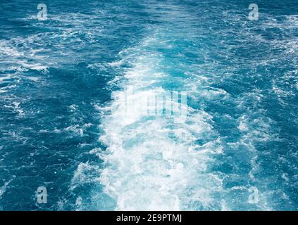 Boat Wave ocean trace on blue sea fresh water background. Deep ocean water surface trail bubble foaming.Travel destination motor boat water traces in Stock Photo
